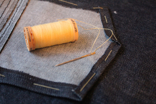 The shape of this denim back pocket is basted before the pocket is topstitched to the garment