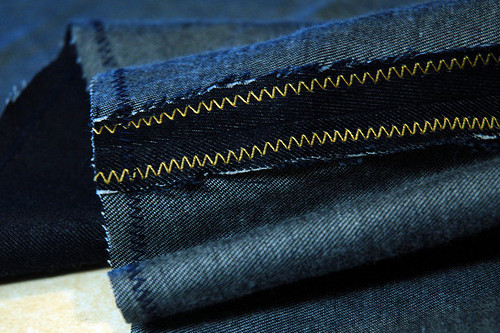 L'intérieur de la jambe sur un jean. La marge de couture est la partie sombre près de la couture. Elle a été zig-zaggée pour l'empêcher de s'effilocher